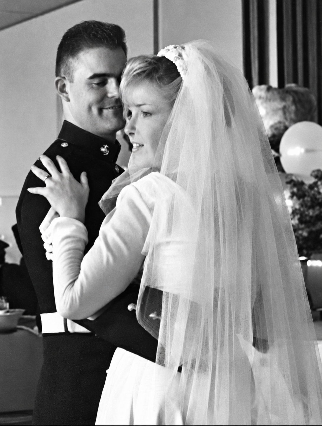 A black-and-white wedding photograph of a couple embracing.